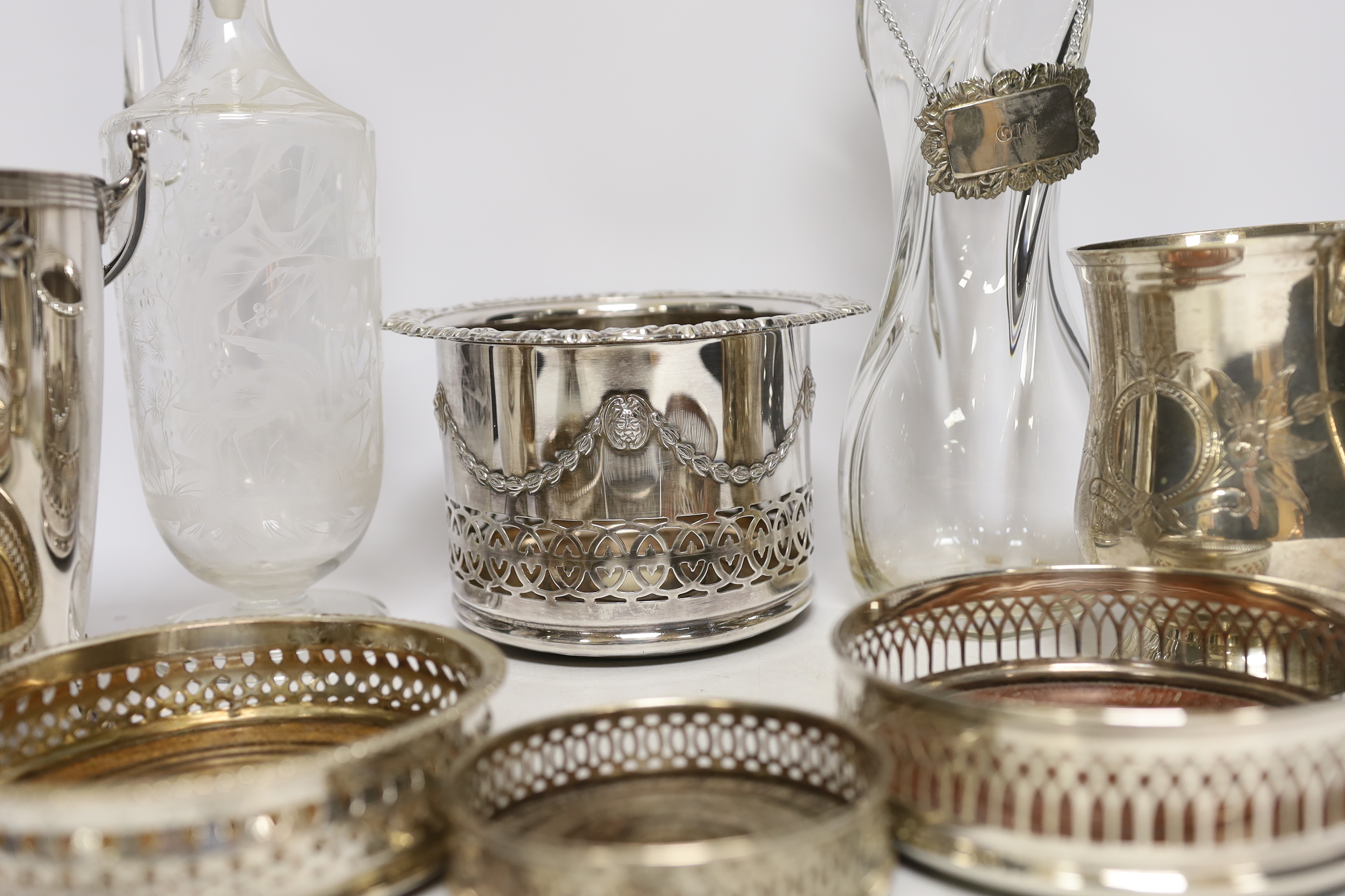 Two decanters; one with silver mount and one with etched body, together four wine coasters, a bucket raised on four feet, etc.